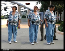 Brunette Busty Grandma with Huge Saggy Boobs in a Colorful Top and Blue Pants Standing in Street.jpg